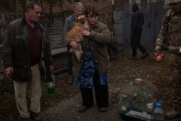 Una donna che tiene in braccio un cane con un uomo accanto a lei.